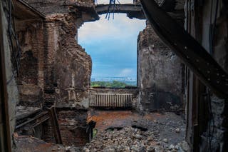 Firefighters work outside a damaged multi-storey residential building, following what local Russian-installed authorities called a Ukrainian military strike