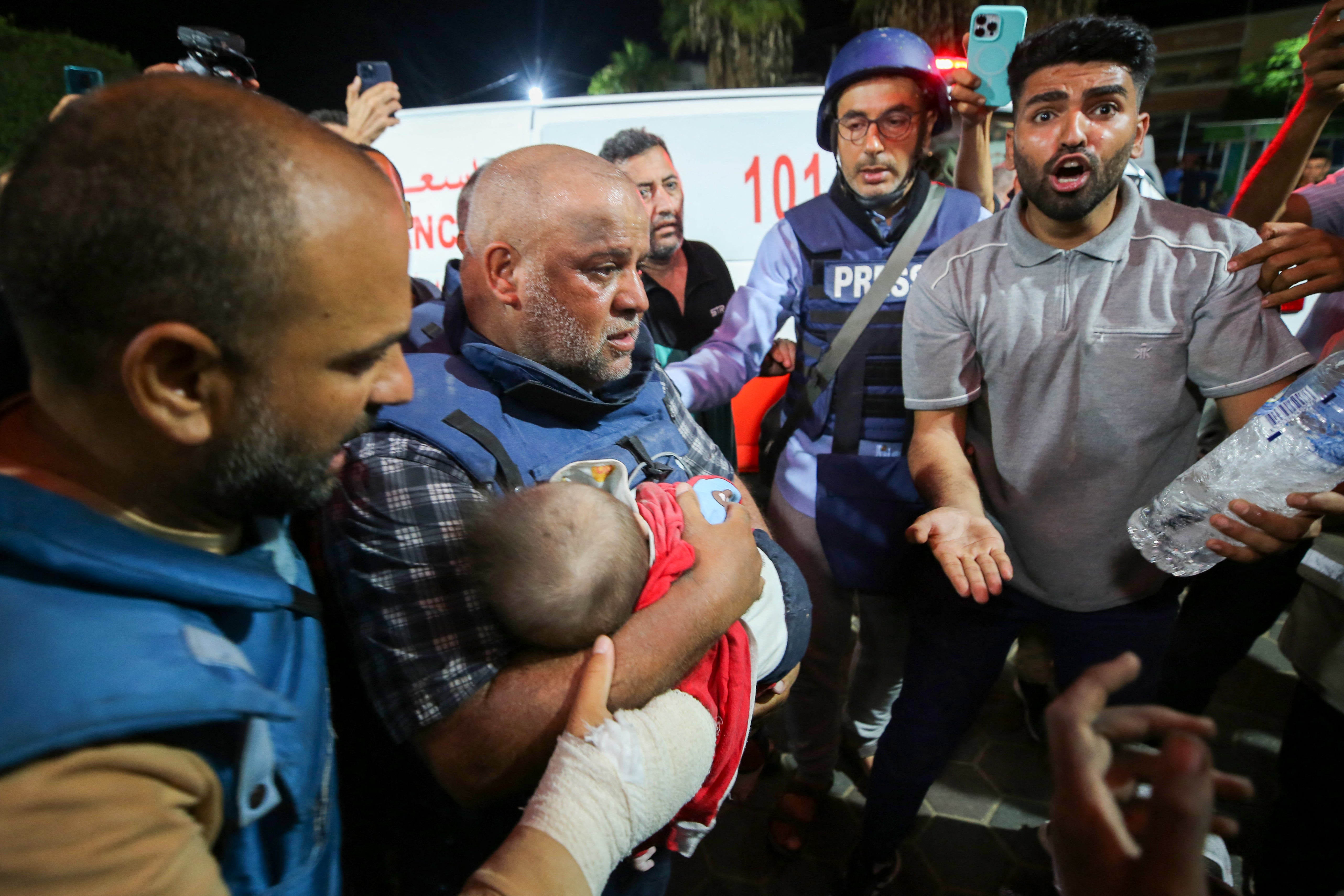 Wael al-Dahdouh cradles the body of his grandchild who was killed along with his wife and two of his children in an Israeli strike in Gaza in October 2023