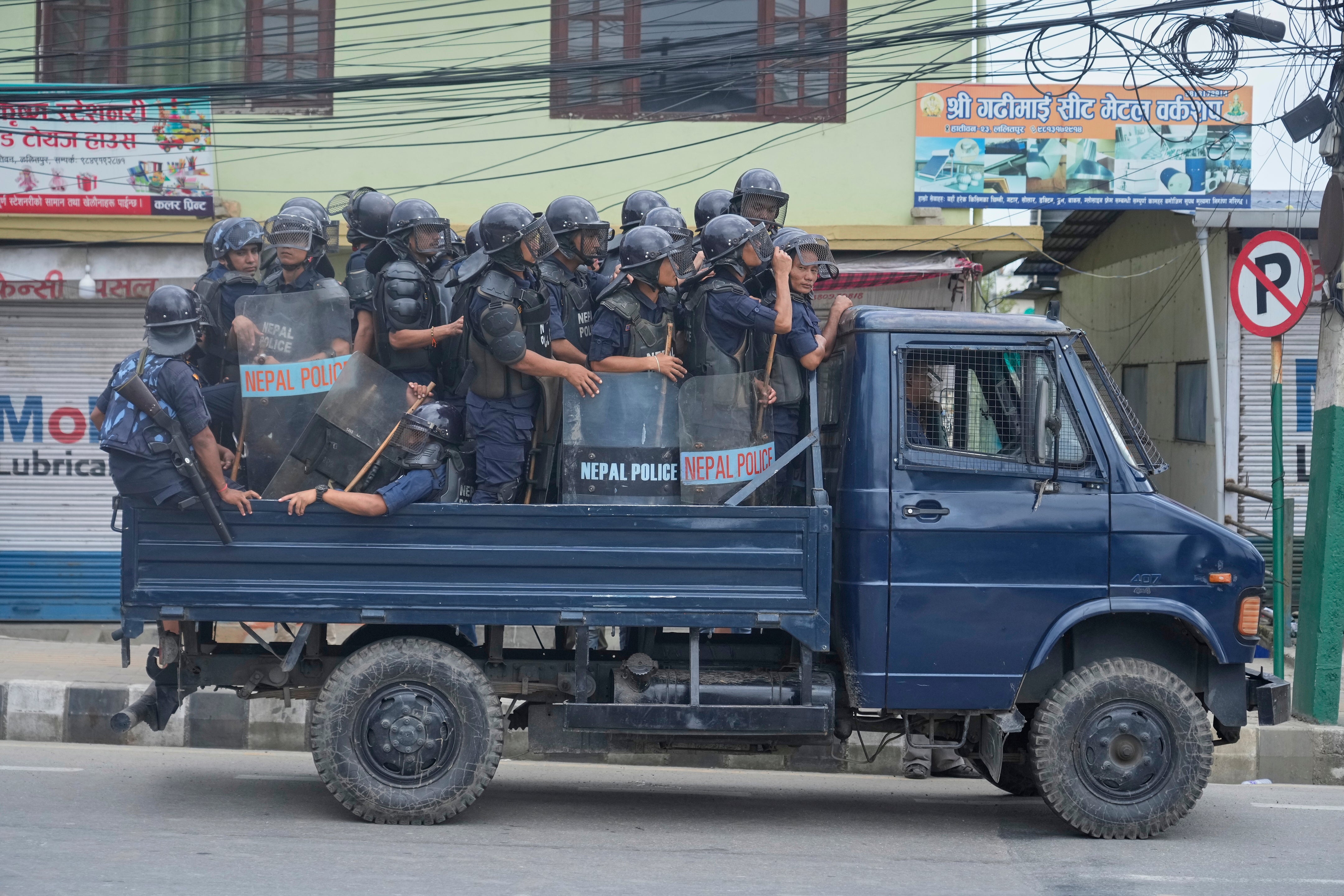 Policemen in riot gear patrol during a curfew in Kathmandu, Nepal, Tuesday