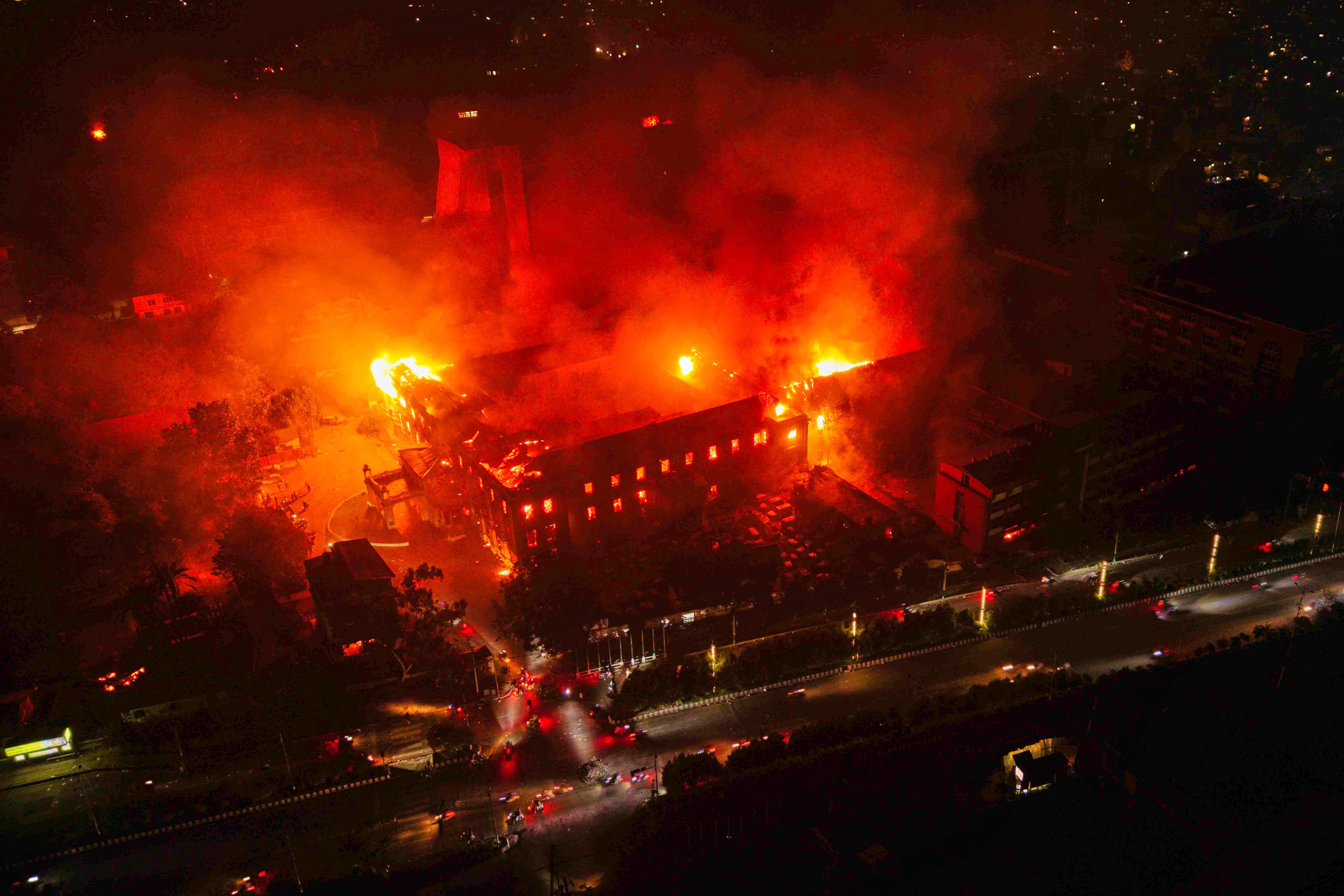 Flames emerge from the parliament building after it was set on fire by protesters