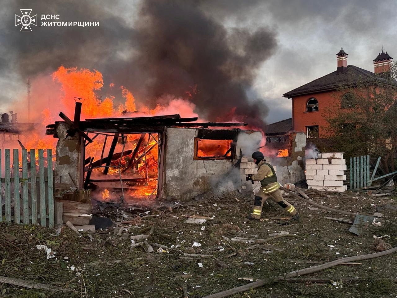 A firefighter runs at the site of a residential area hit during Russian drone and missile strikes in Zhytomyr, Ukraine