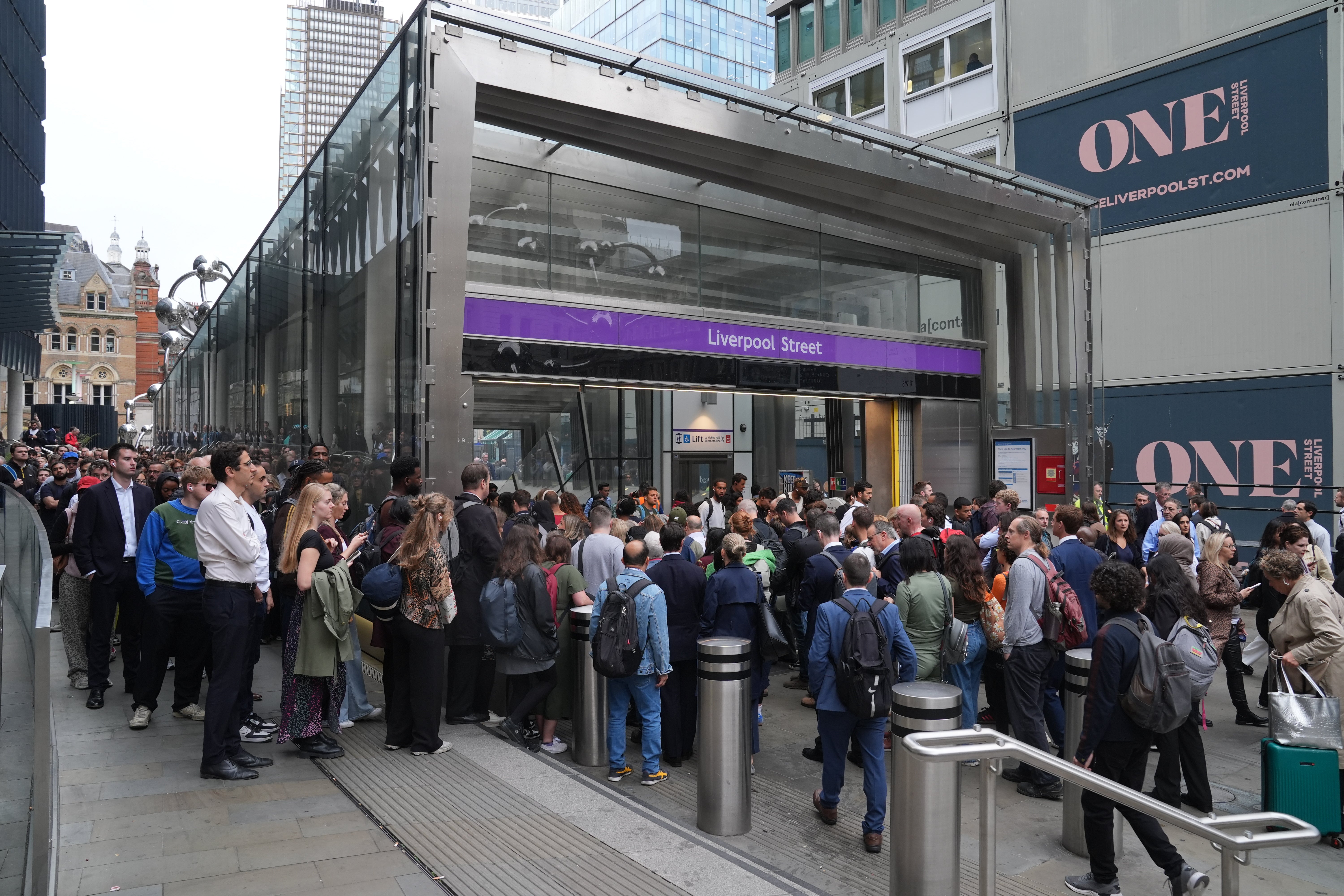 Passengers queue up outside the Liverpool Street station and try to be on the Elizabeth train train