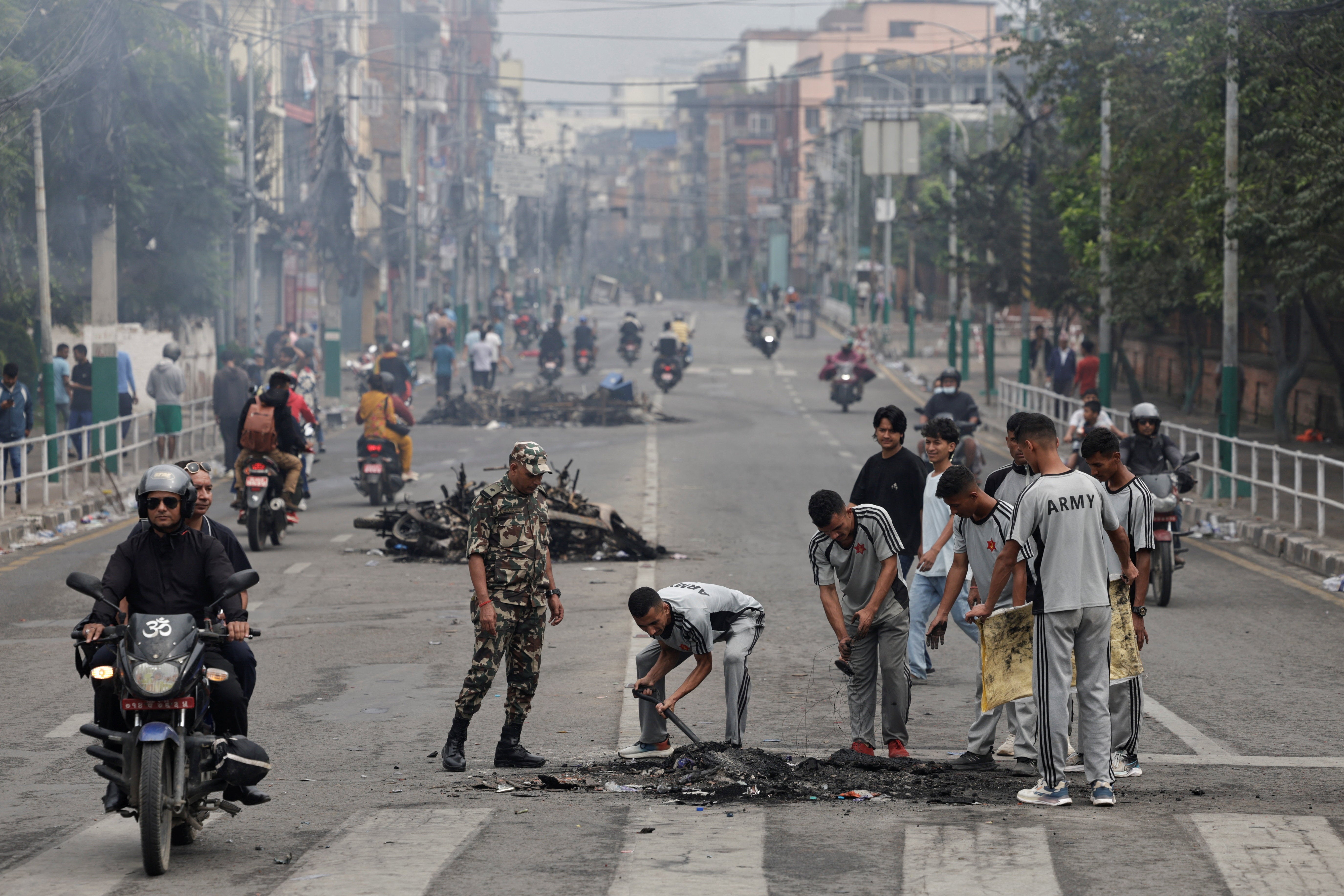 Nepali army soldiers clear debris from a road near the Singha Durbar office complex that houses the prime minister’s office