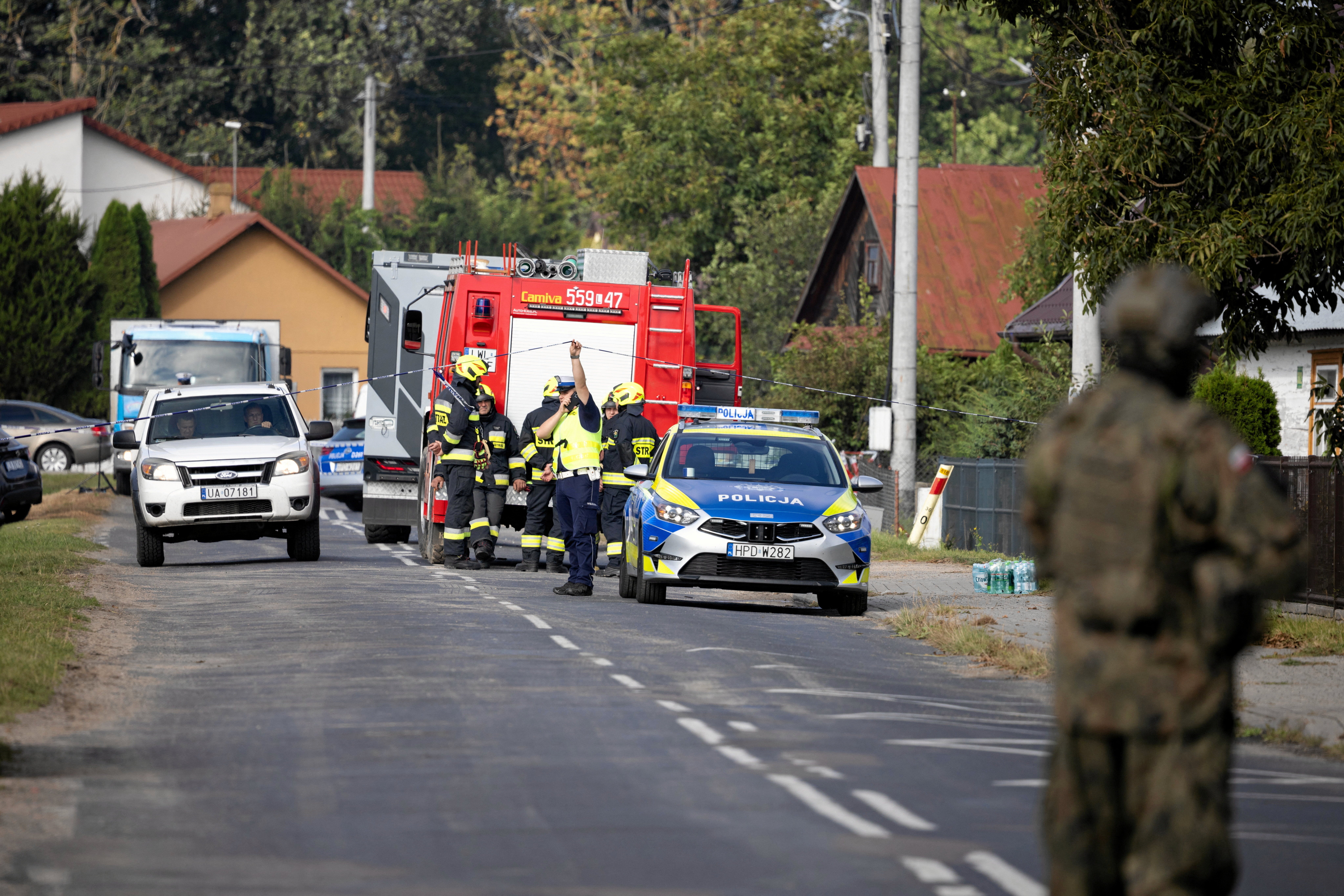<p>A soldier, firefighters and a police officer stand on the street after a drone or similar object struck a residential building according to local authorities, following violations of Polish airspace during a Russian attack on Ukraine, in Wyryki municipality, Poland September 10, 2025</p>