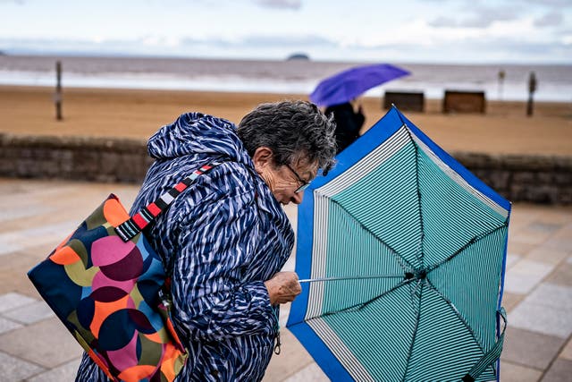 <p>Umbrellas come out on the promenade at Weston-super-Mare, Somerset</p>