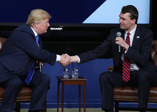 <p>Charlie Kirk shakes hands with President Donald Trump at a Turning Point USA event in March 2018</p>