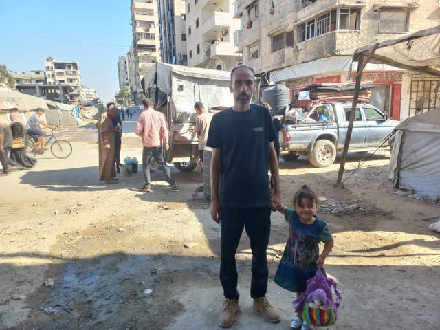 <p>Palestinian journalist Nedal Hamdouna and his three-year-old daughter prepare to flee for the eighth time as Israeli forces  advance in Gaza</p>