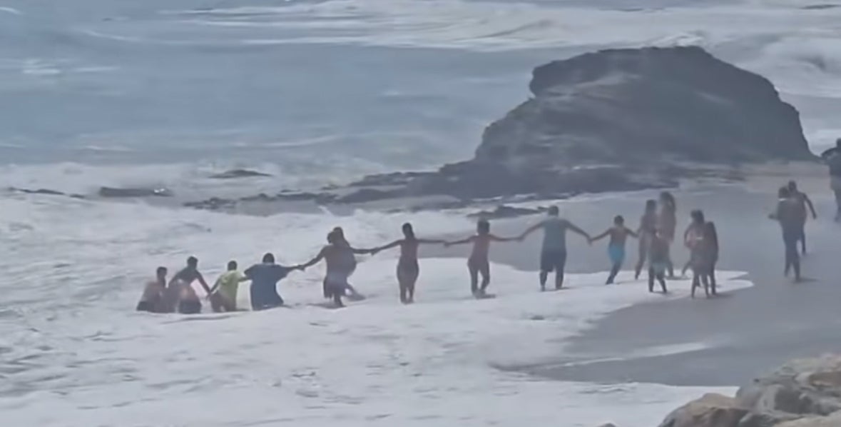 <p>People on a Costa del Sol beach formed together to create a human chain to rescue a young boy and a man who had tried to save him </p>