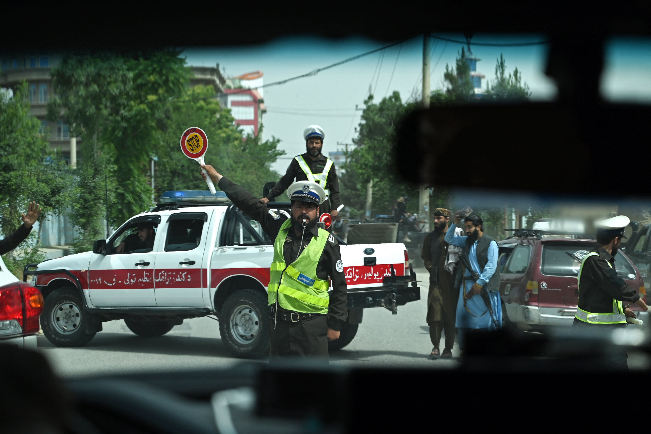 An Afghan traffic policeman directs a UN convoy outside in Kunduz