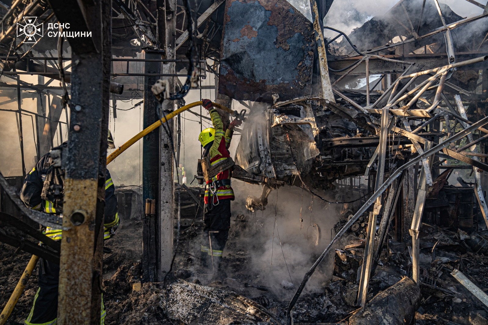 Firefighters work at the site of a Russian drone strike in Sumy, Ukraine, on Friday