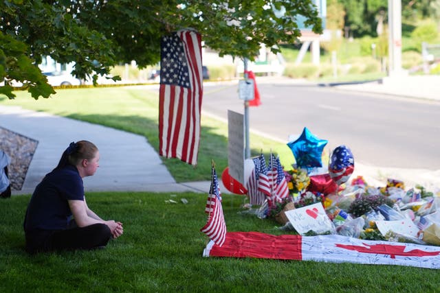 <p>Alicia Daley sits at a memorial for Charlie Kirk</p>