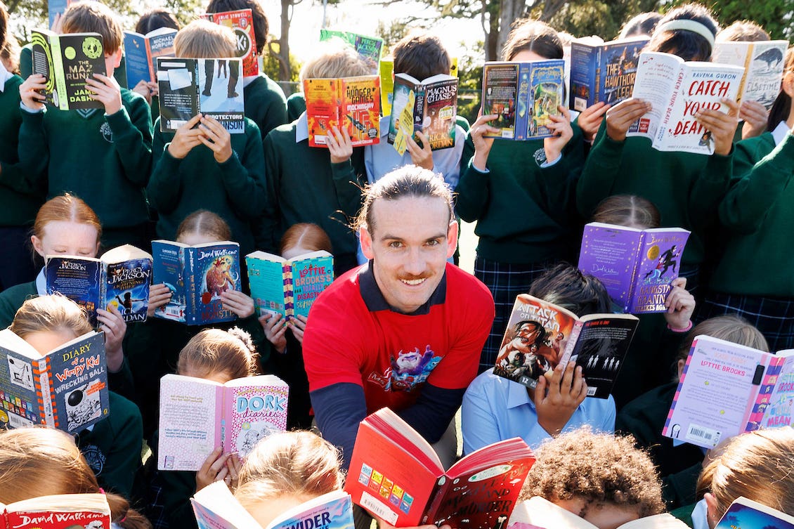Cillian O’Sullivan, who is living with MS, pictured with students from Rathdown School in Dublin (Andres Poveda/PA)