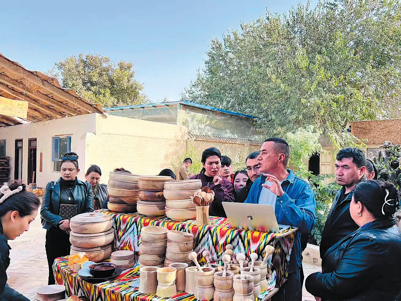Erxat Ibrayim (third from right) welcomes visitors to his workshop in Hotan prefecture, Xinjiang Uygur autonomous region