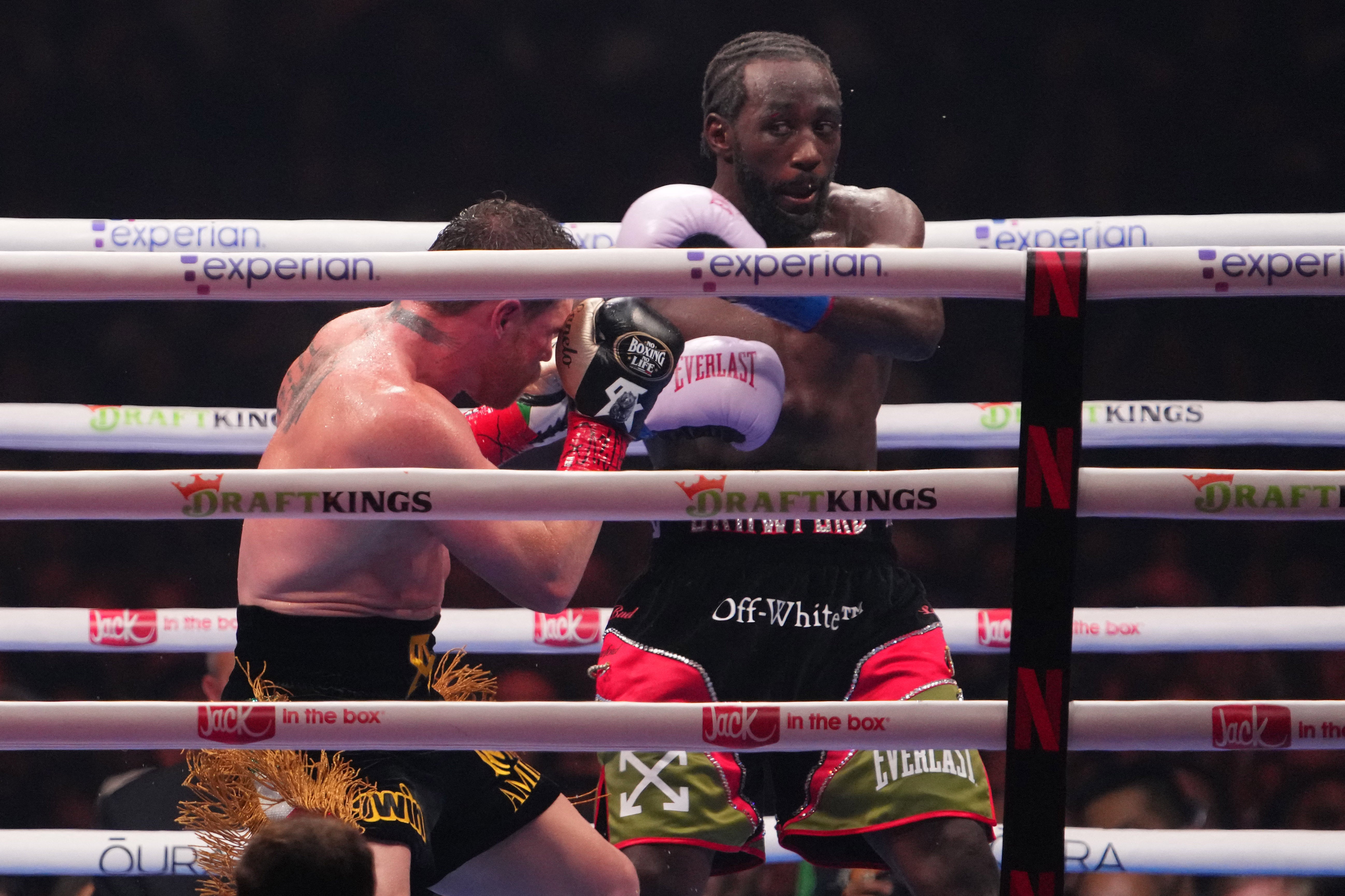 <p>Canelo Alvarez (black/gold trunks) and Terence Crawford (black/red trunks) box during their super middleweight title bou</p>