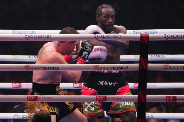 <p>Canelo Alvarez (black/gold trunks) and Terence Crawford (black/red trunks) box during their super middleweight title bou</p>