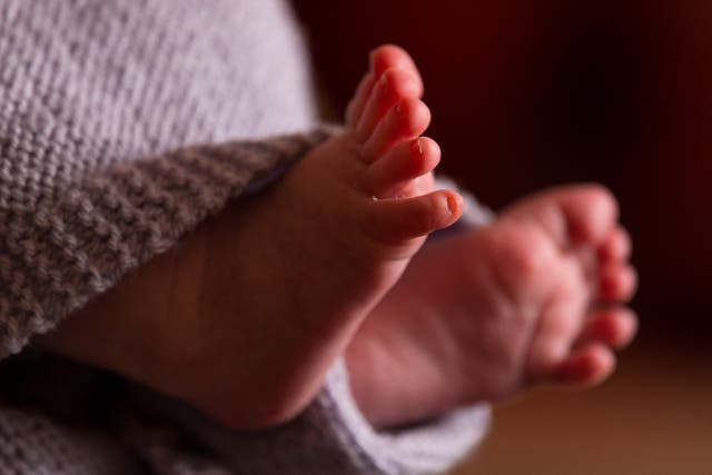 The feet of a new baby wrapped in a blanket.