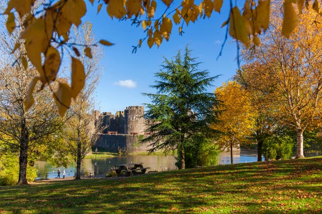<p>Autumn colours frame Caerphilly Castle in Cardiff</p>