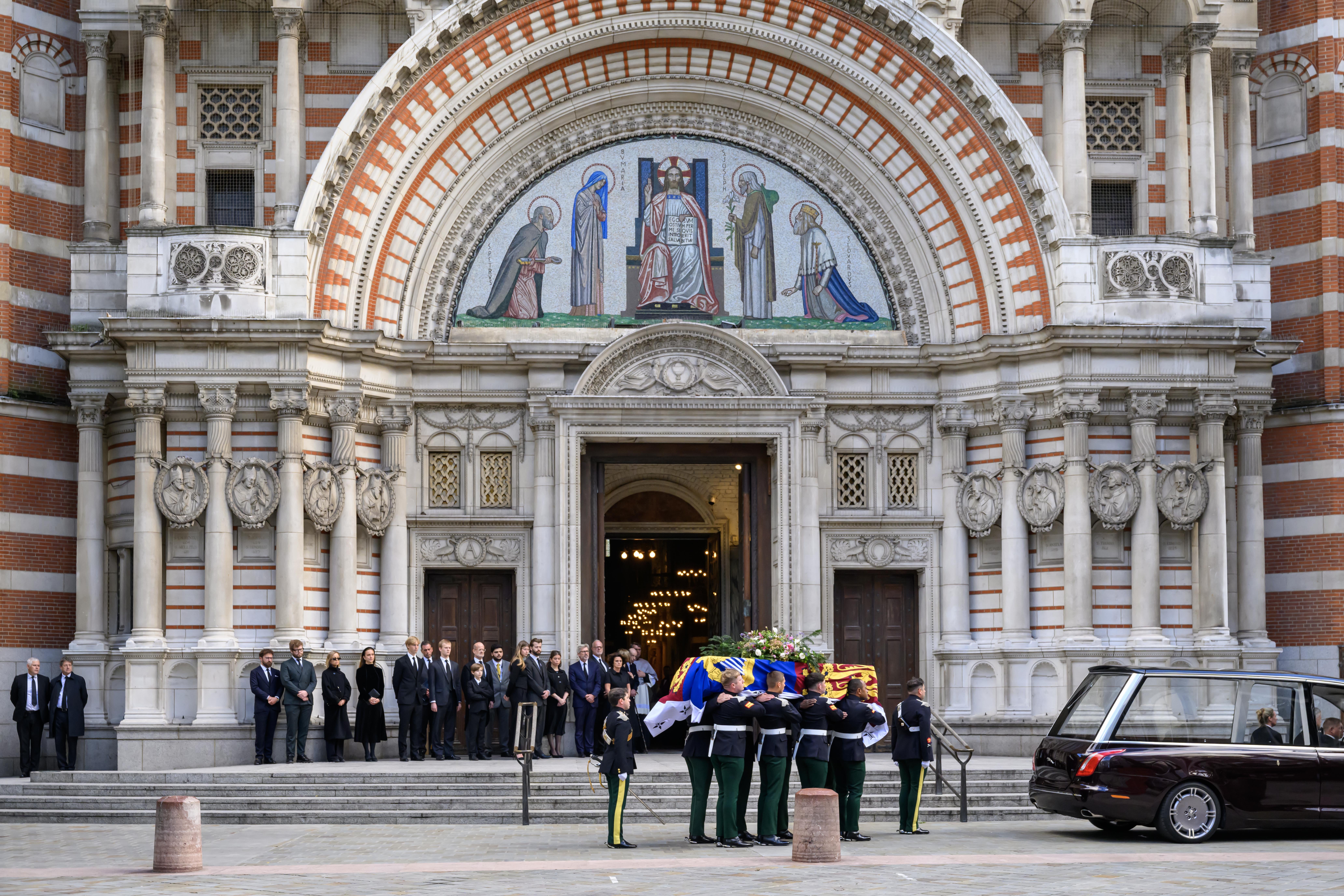 <p>Members of the royal family stand together as the coffin of the Duchess of Kent arrives at Westminster Cathedral on Monday evening</p>