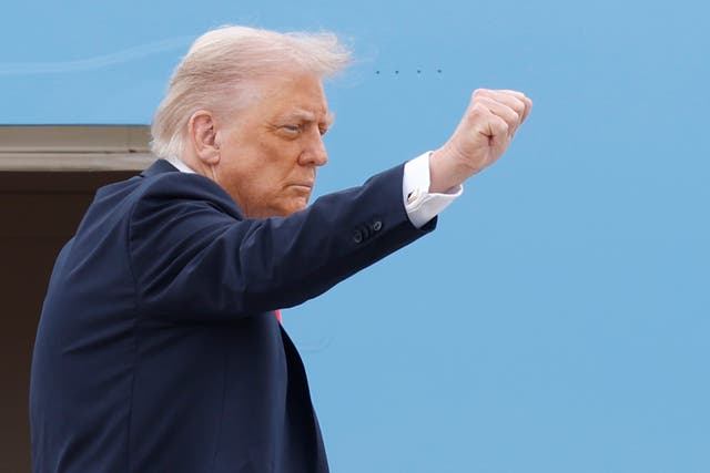 <p>President Donald Trump gestures as he boards Air Force One at Joint Base Andrews (Luis M Alvarez/AP)</p>