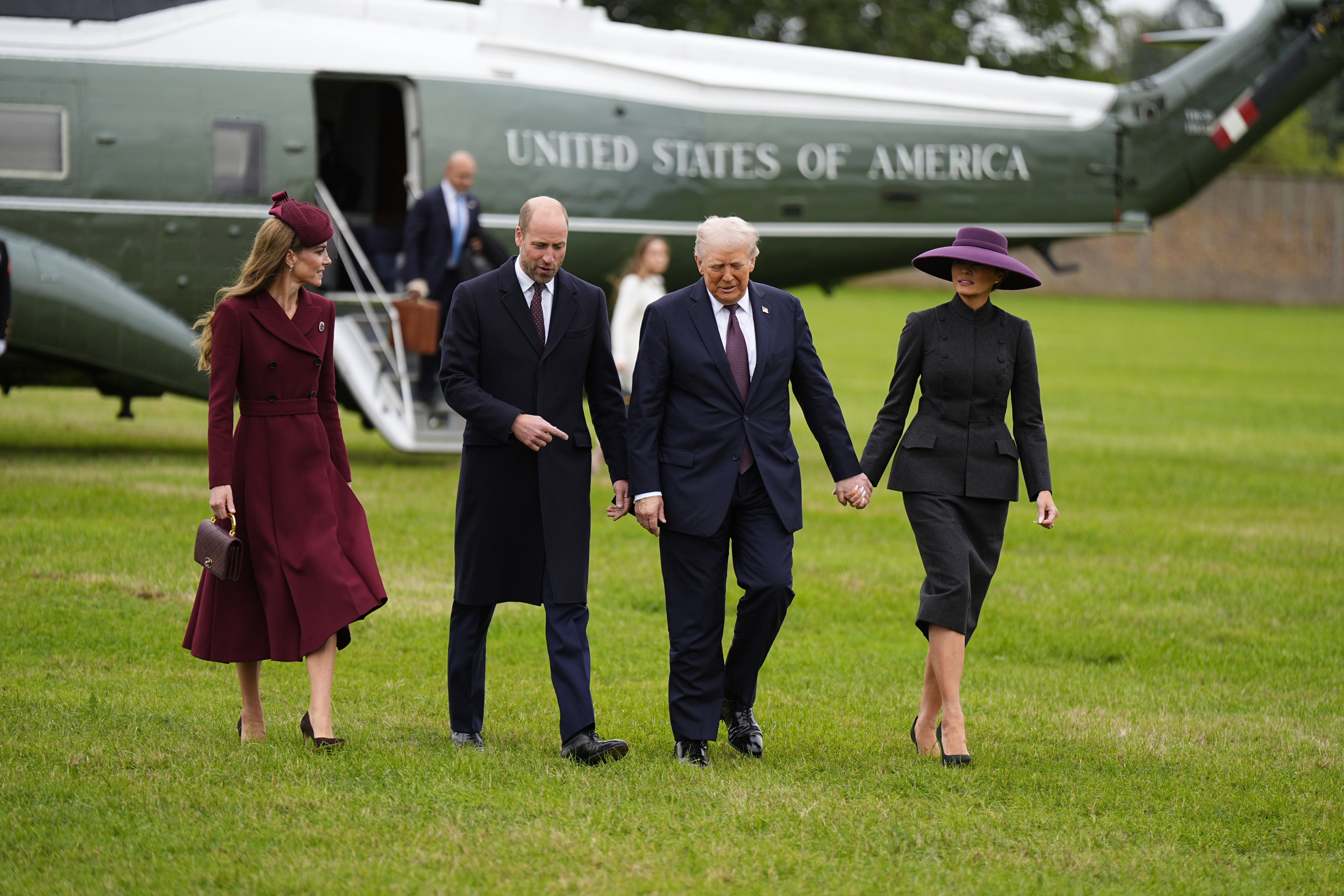 Kate wore a burgundy Emilia Wickstead dress while Melania wore a wide-brimmed purple hat