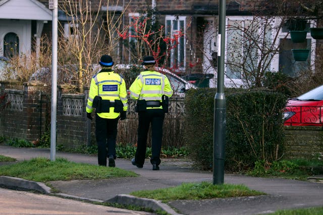A Sussex police officer and a Community Support Officer walk along a street in Crawley, Sussex (PA)