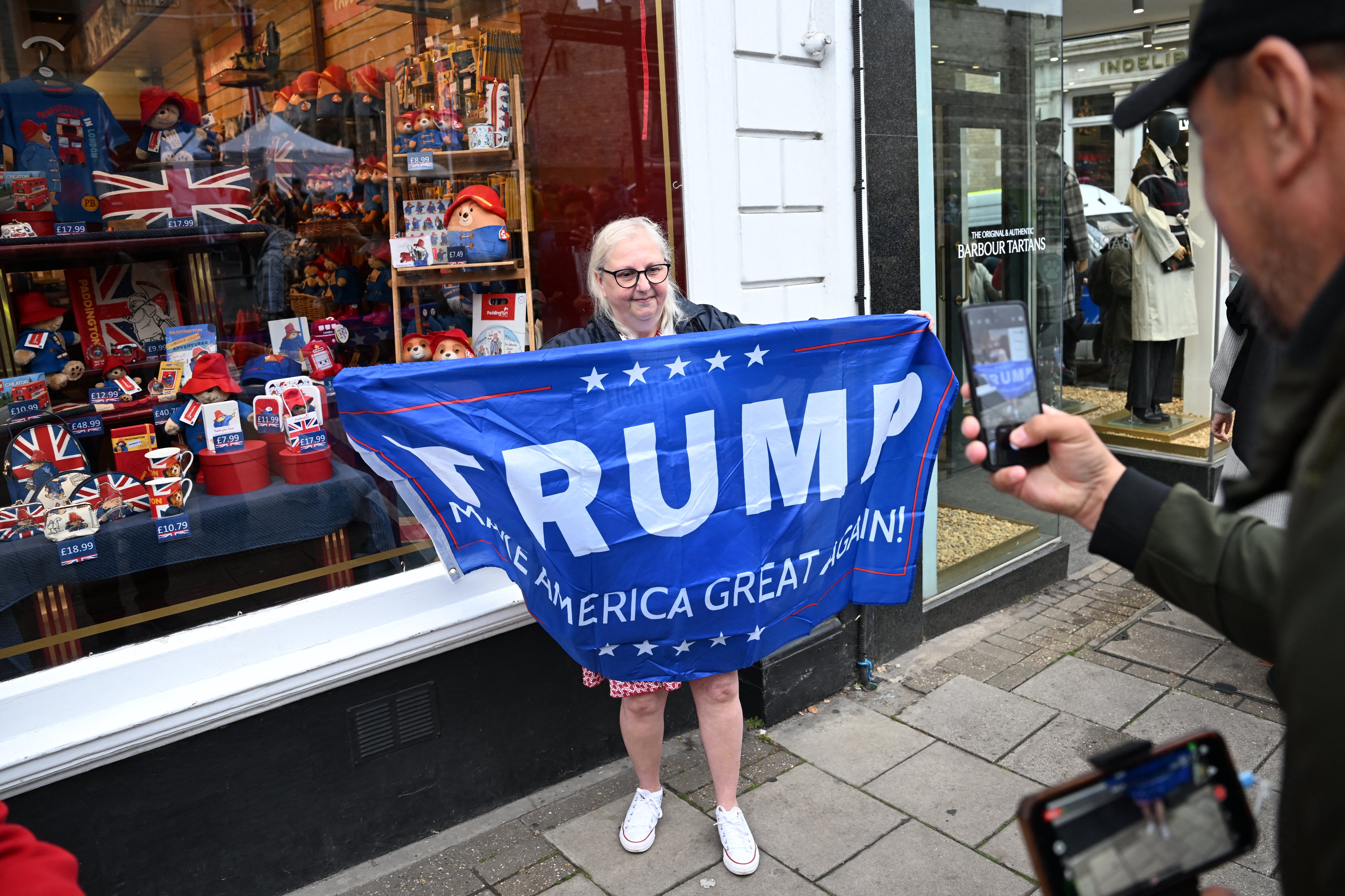 A person holds a banner reading 'Trump, Make America Great Again' near Windsor Castle