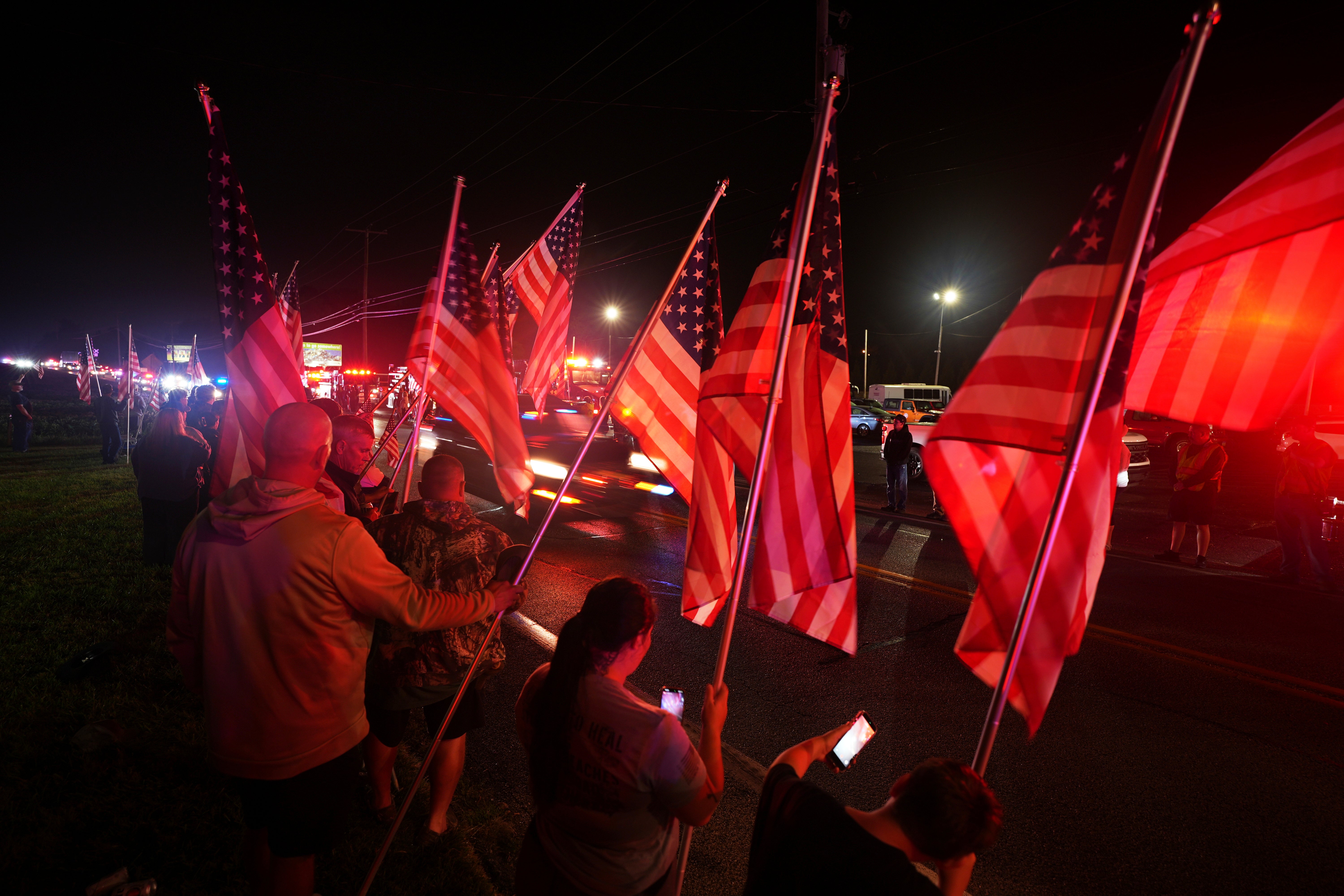 People hold American flags during a procession Wednesday, Sept. 17