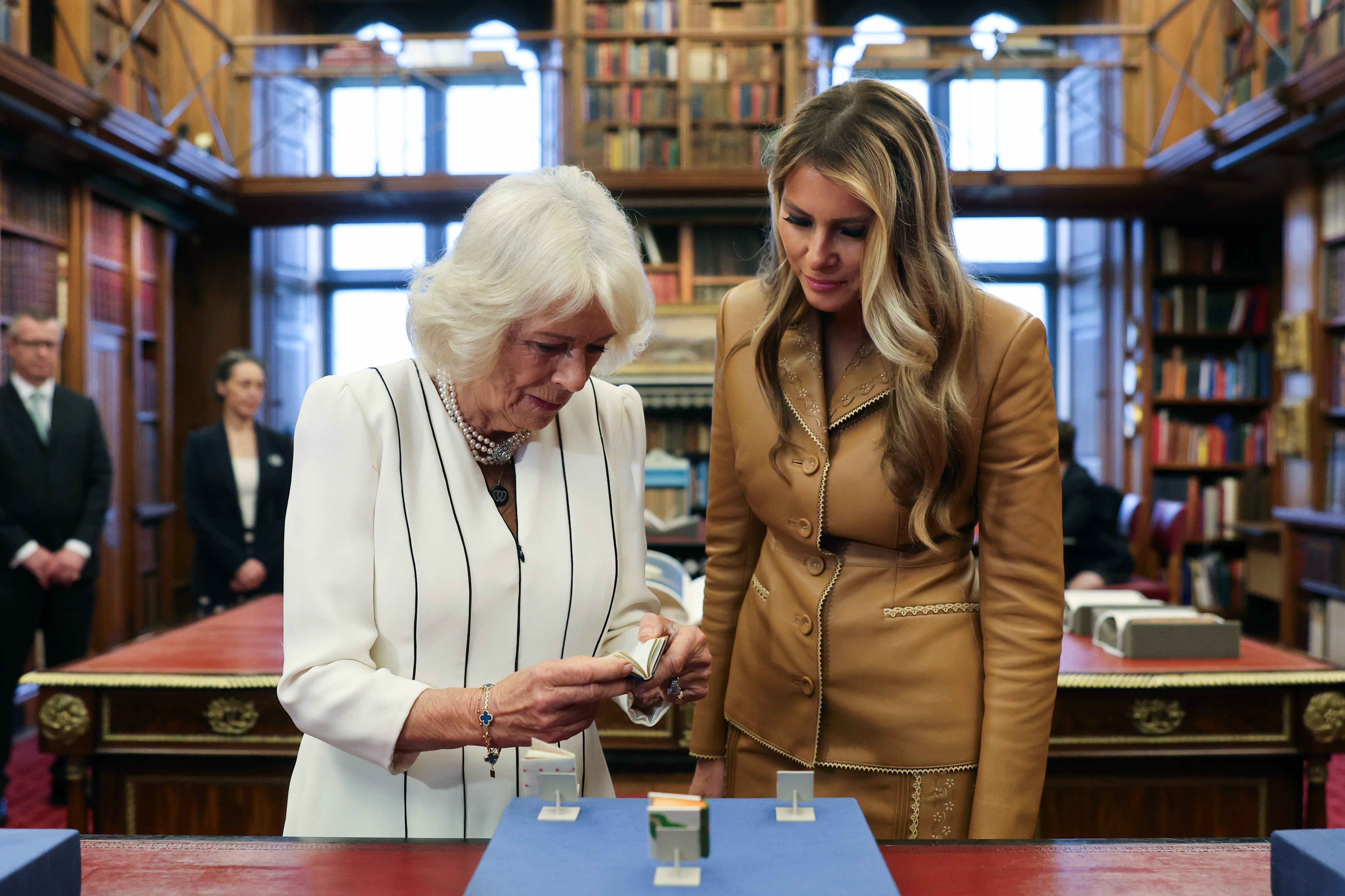 Queen Camilla and First Lady Melania Trump inspect a tiny book as they tour Queen Mary’s Dolls’ House and the Royal Library