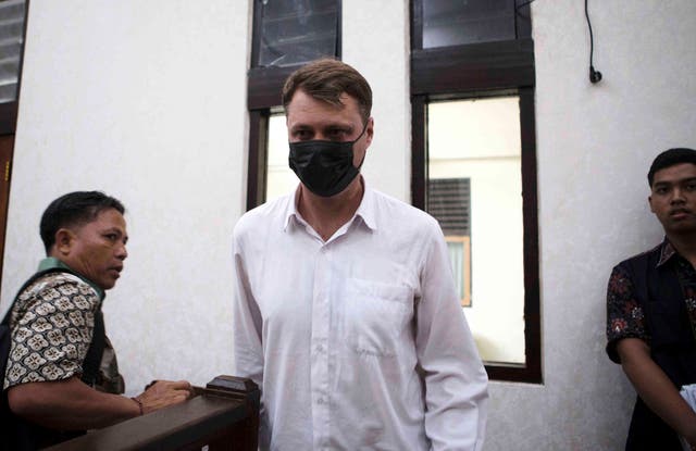 <p>Ukrainian citizen Roman Nazarenko, centre, who is on trial on accusation of running a drug lab on the resort island of Bali, arrives for a hearing at the district court in Denpasar, Indonesia, Thursday, 18 September 2025</p>