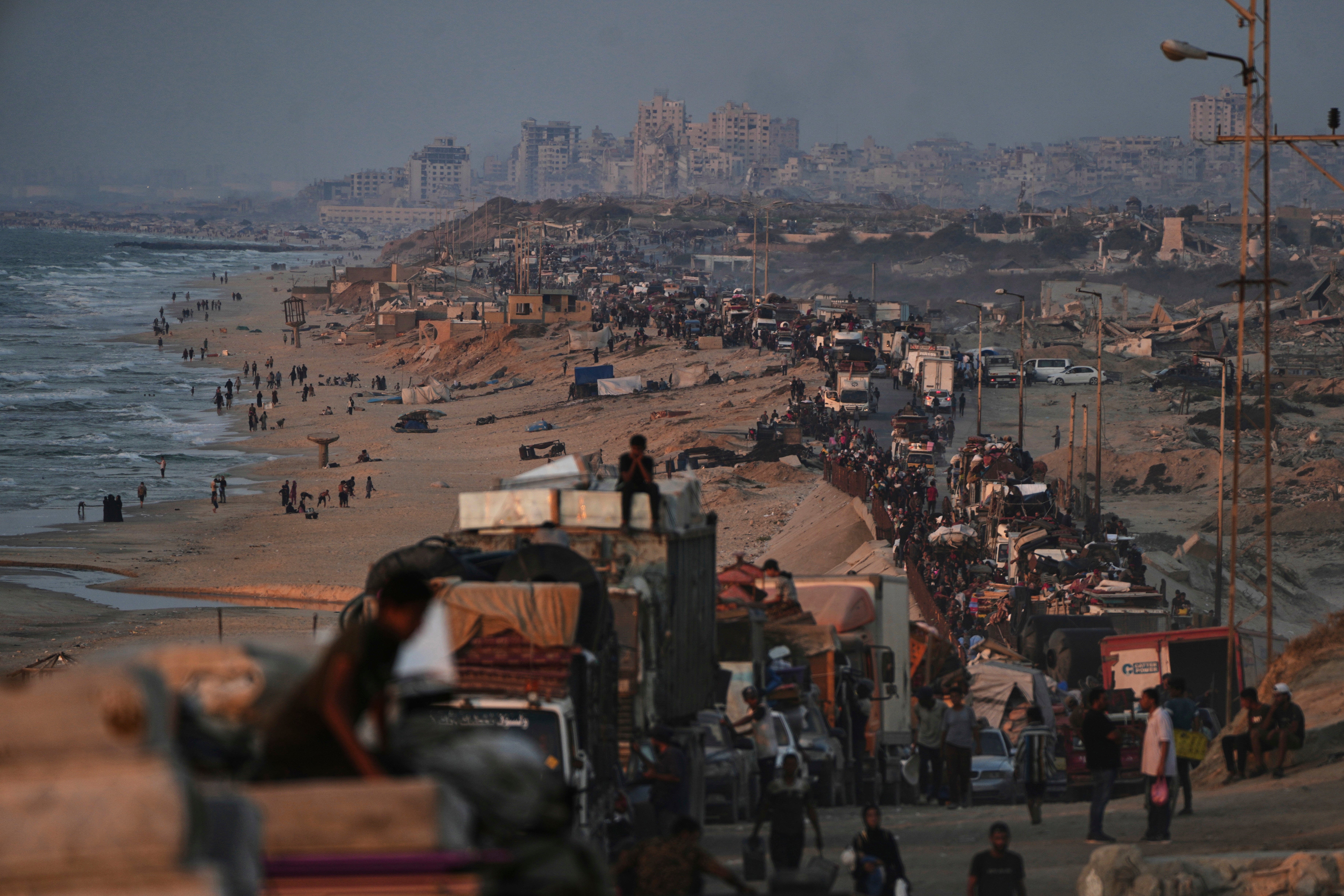 Displaced Palestinians flee Gaza City, carrying their belongings along the coastal road toward southern Gaza