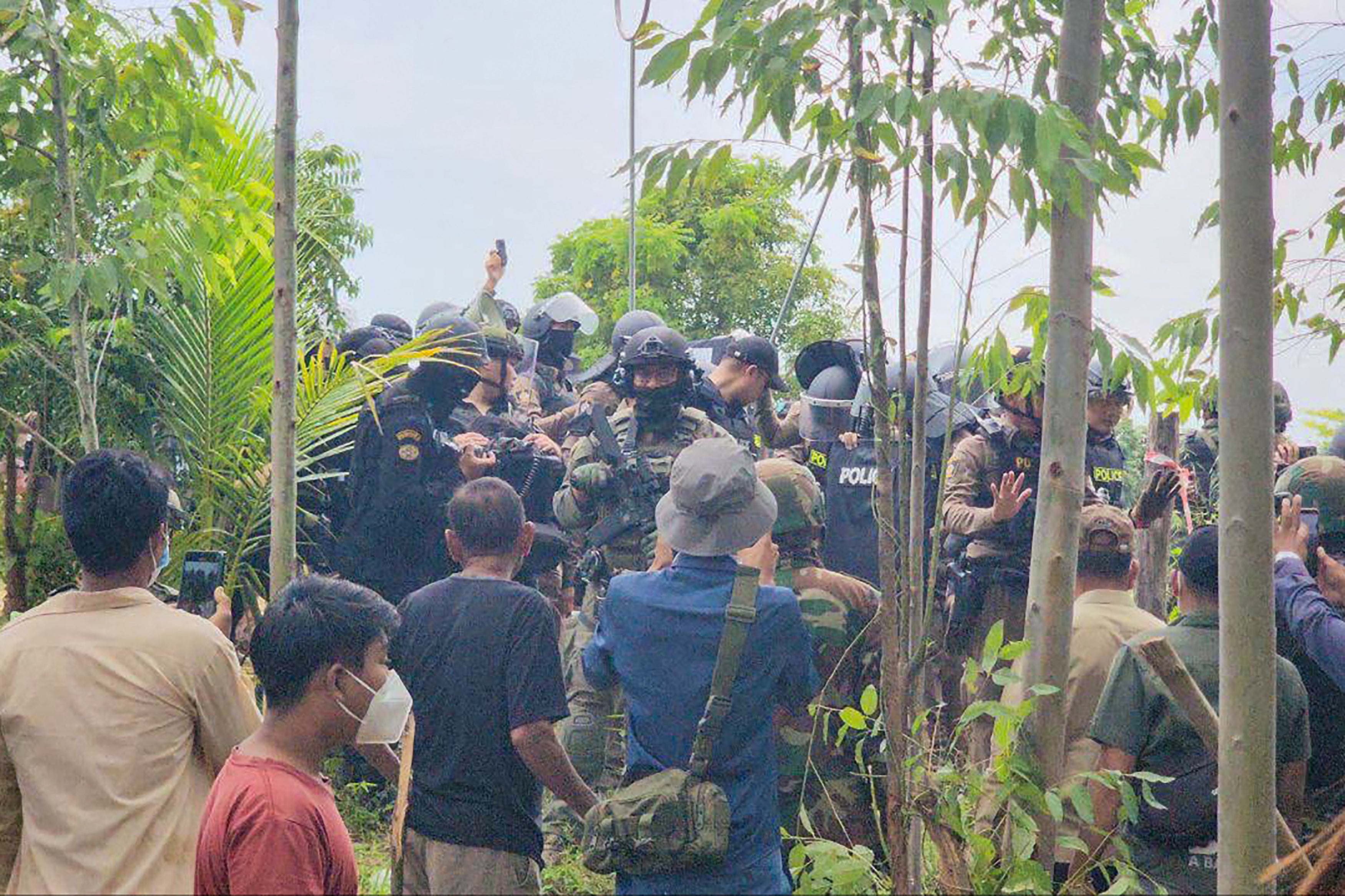 Cambodian people confront Thai police and soldiers in a disputed area along the border in Banteay Meanchey province