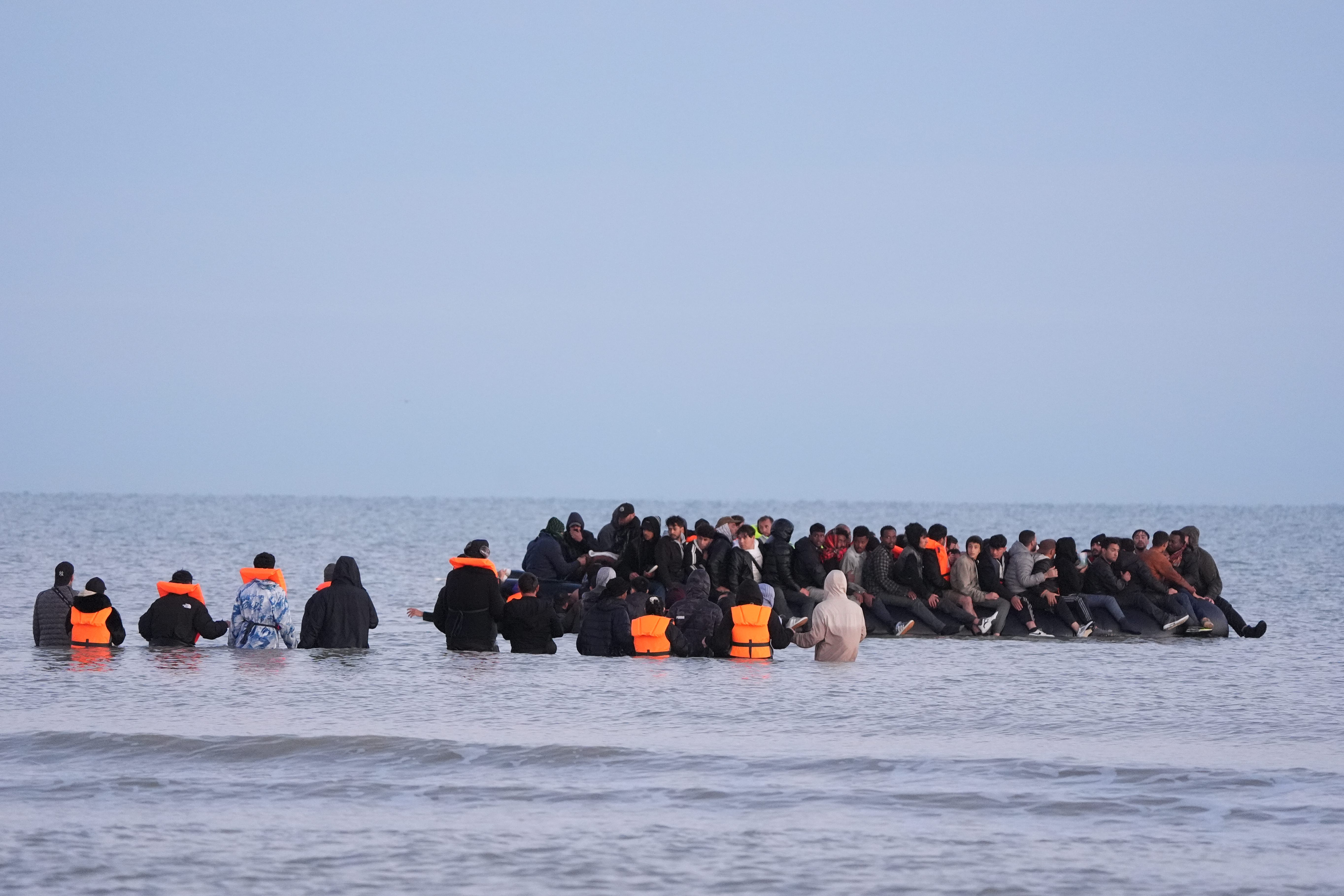 A group of people thought to be migrants wade into the sea near Gravelines in France to join a boat (Gareth Fuller/PA)