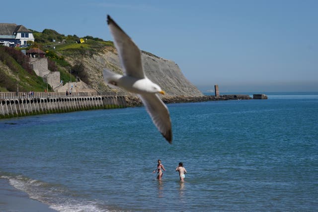 Two women cool off in the sea in Folkestone, Kent (Gareth Fuller/PA)