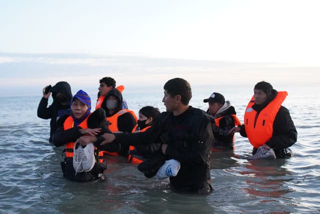 A group of people thought to be migrants wade into the sea near Gravelines in France (Gareth Fuller/PA)