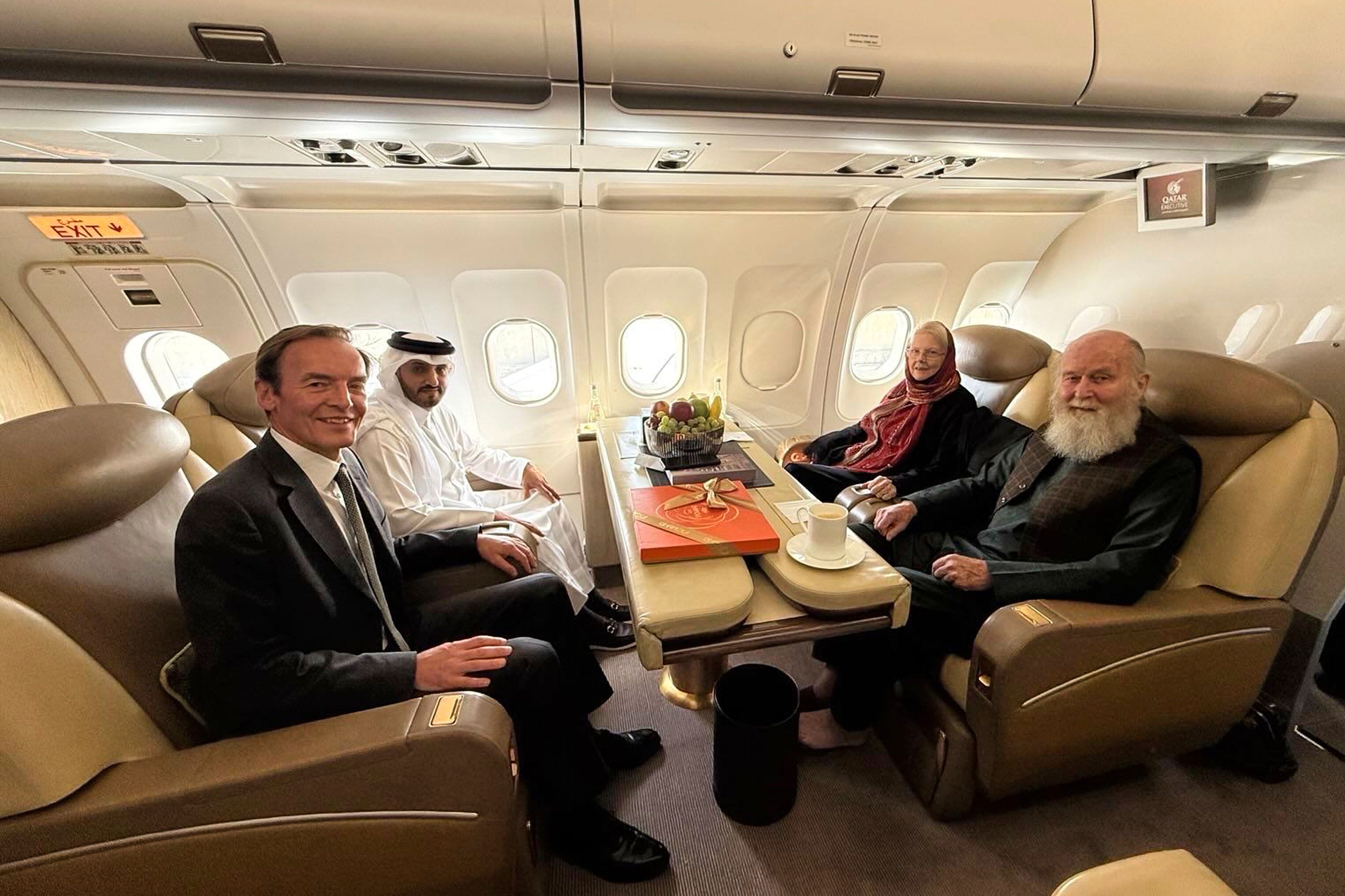 Barbie and Peter Reynolds, right, sitting opposite UK and Qatari diplomats on a plane (Qatar Foreign Ministry via AP)
