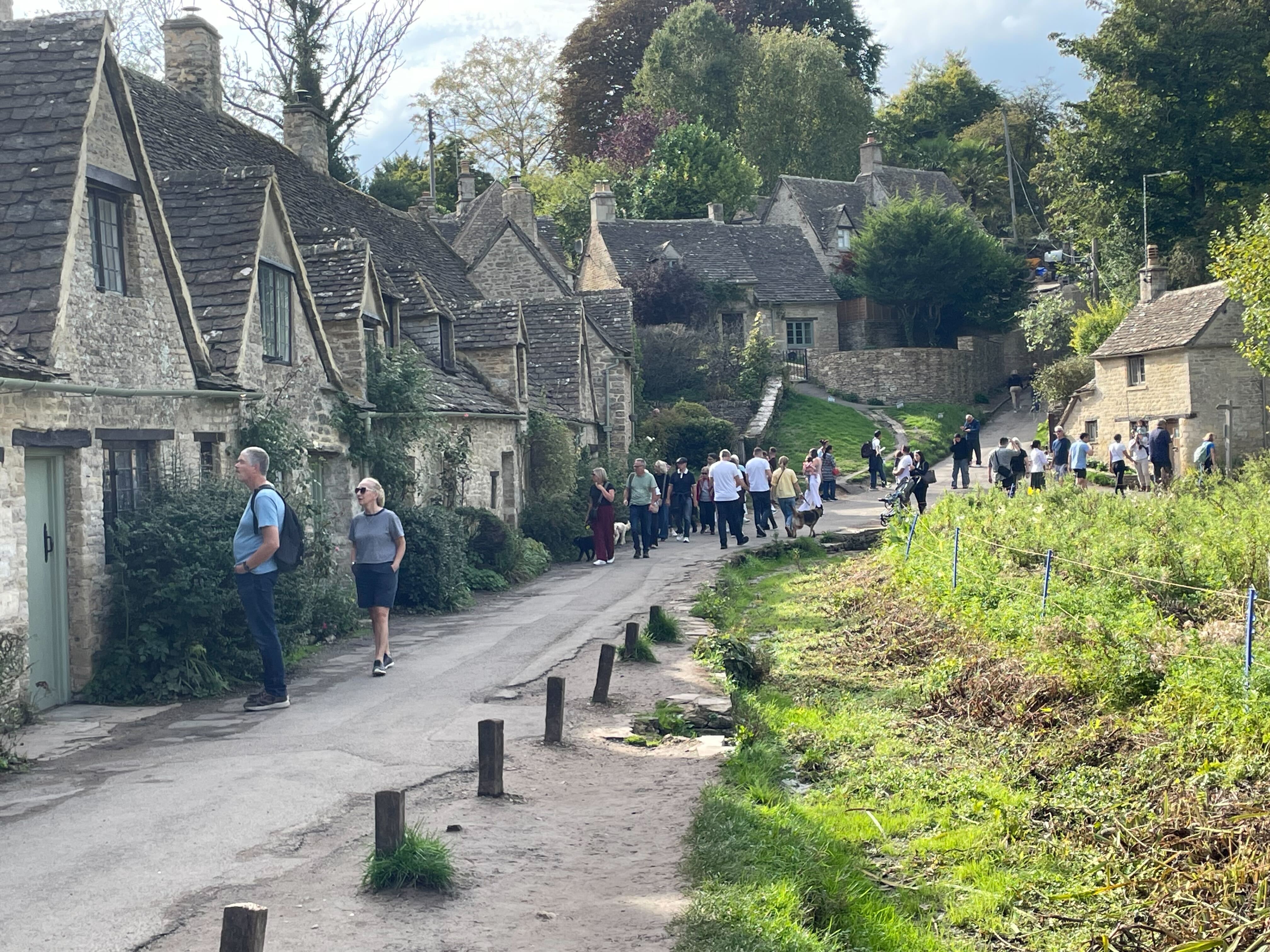 Tourists walk along the line of former weavers’ cottages in Bibury, which sits on a circular walk around the village
