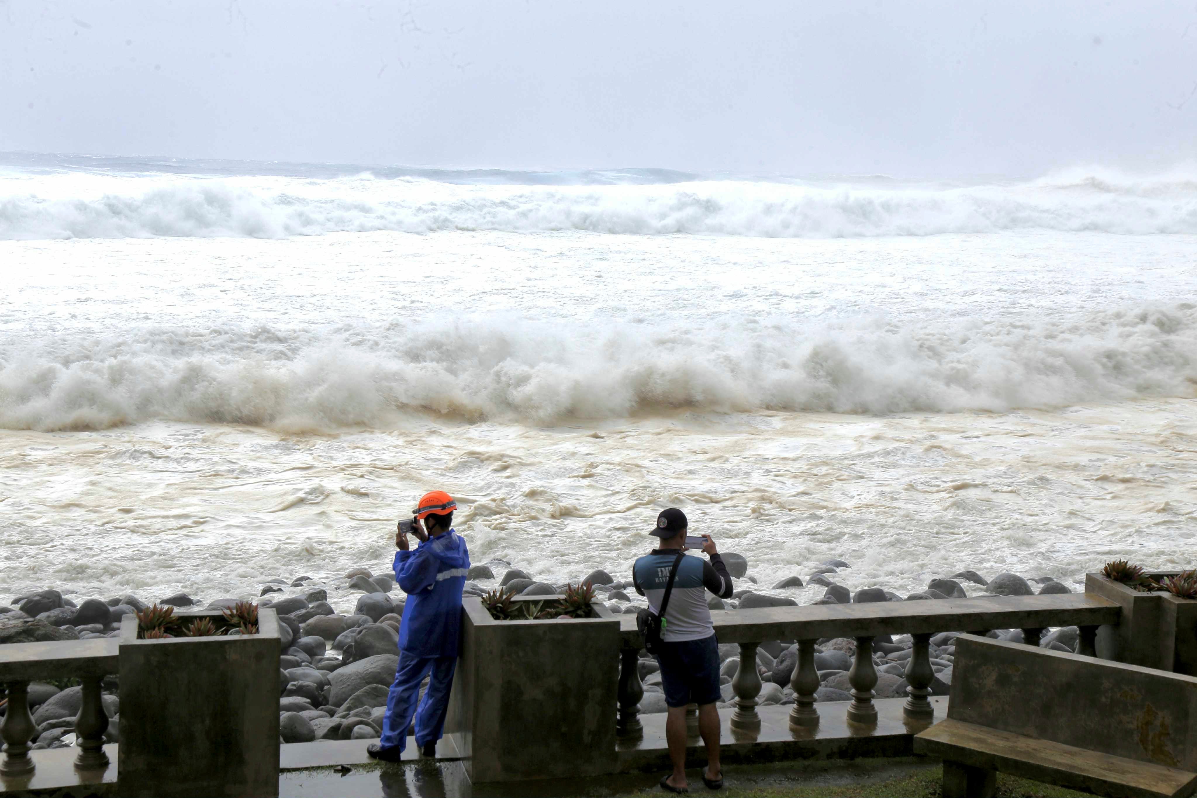 People watch as strong waves batter Basco, Batanes province, northern Philippines, as Typhoon Ragasa affects the area on Monday, 22 September 2025