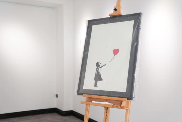 <p>A Banksy painting, <em>Girl With Balloon</em>, on display at the Grove Gallery </p>