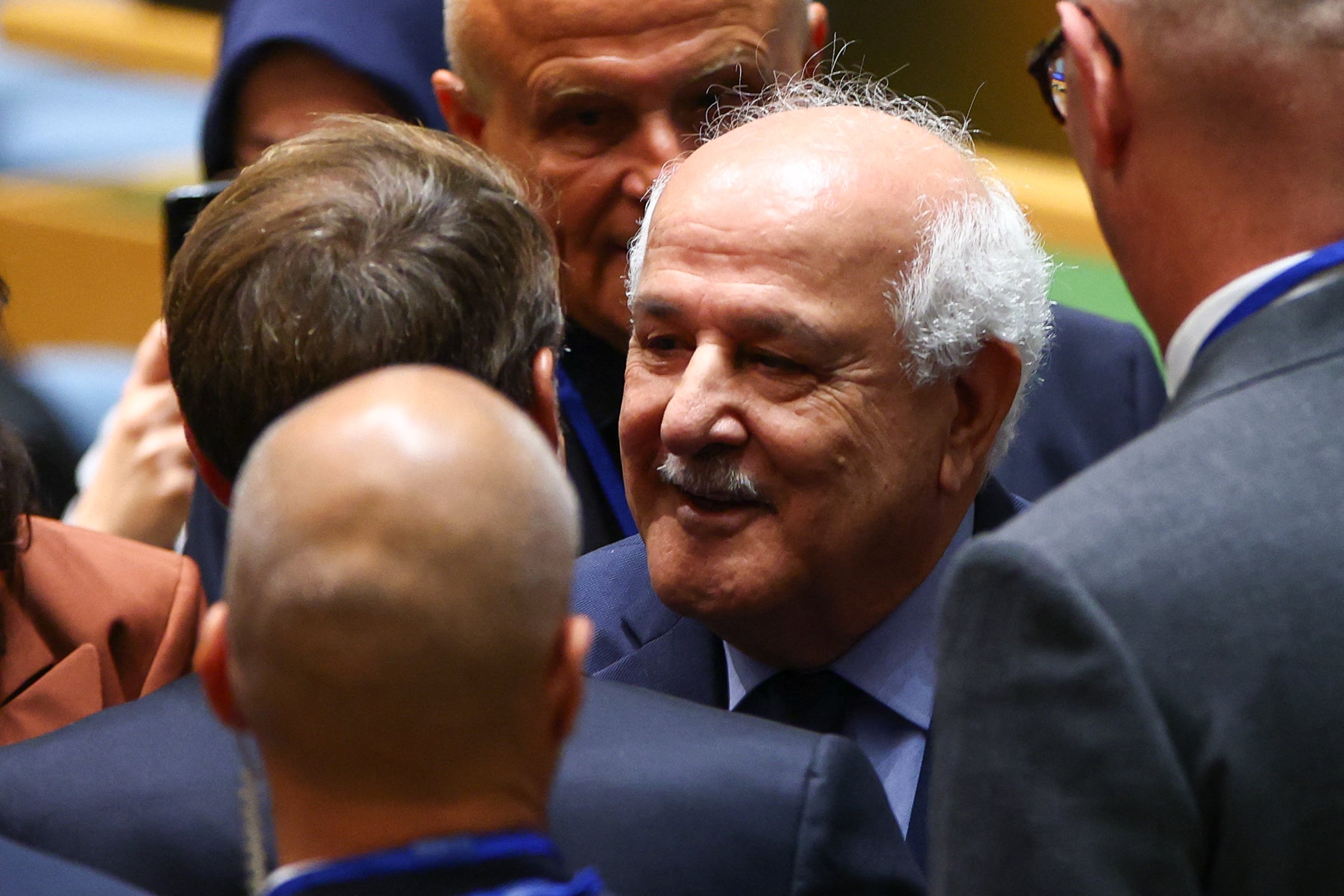 Palestinian Ambassador to the UN Riyad Mansour greets Emmanuel Macron as they arrive for a United Nations Summit on Palestinians at UN headquarters