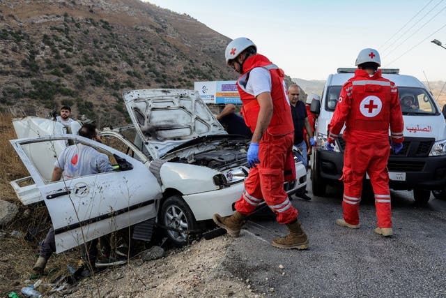 <p>First responders and security forces' members gather at the site of an Israeli strike on a vehicle on the Khardali road in south Lebanon's Marjayoun area </p>