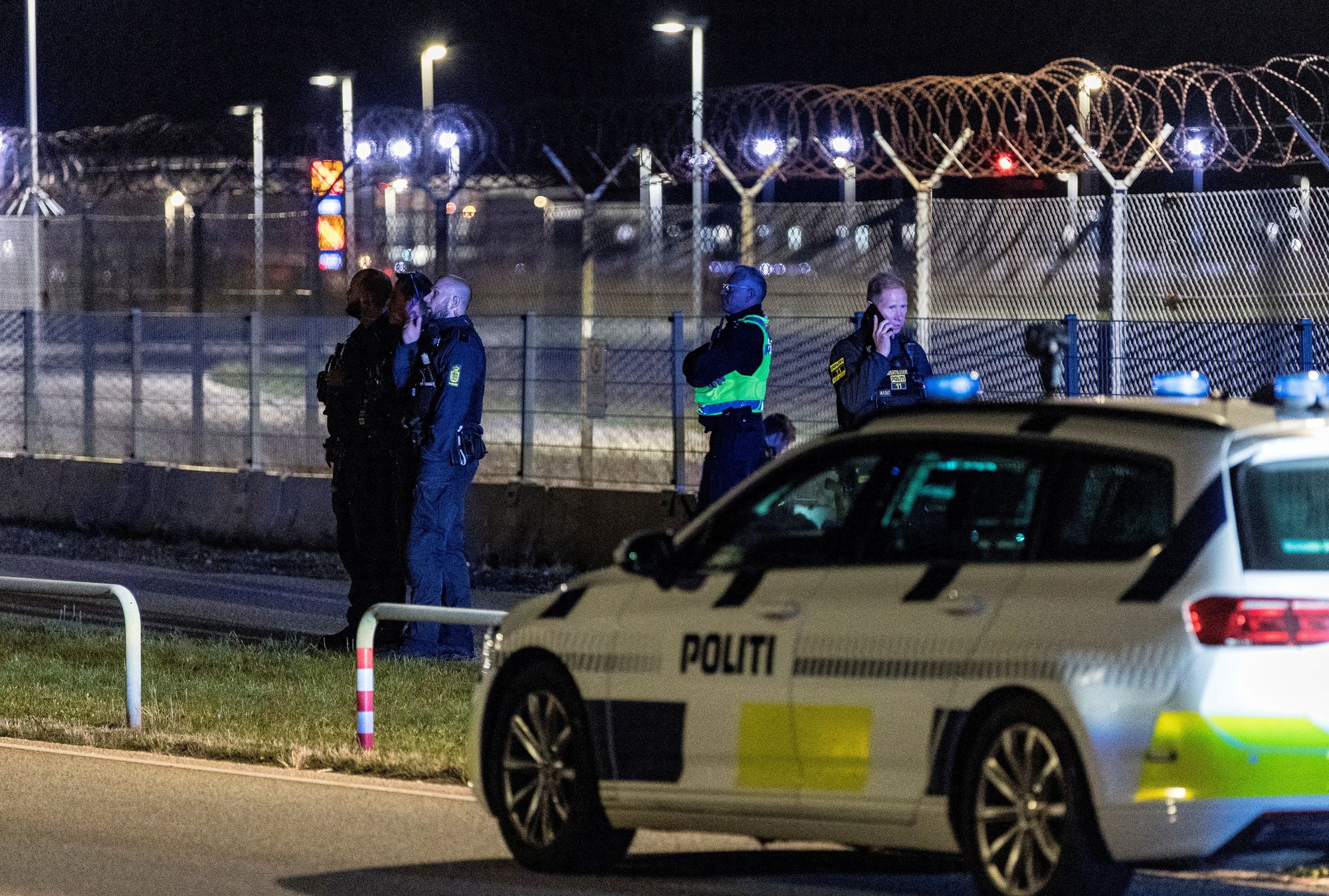 Police officers stand guard after all traffic has been closed at the Copenhagen airport due to drone reports