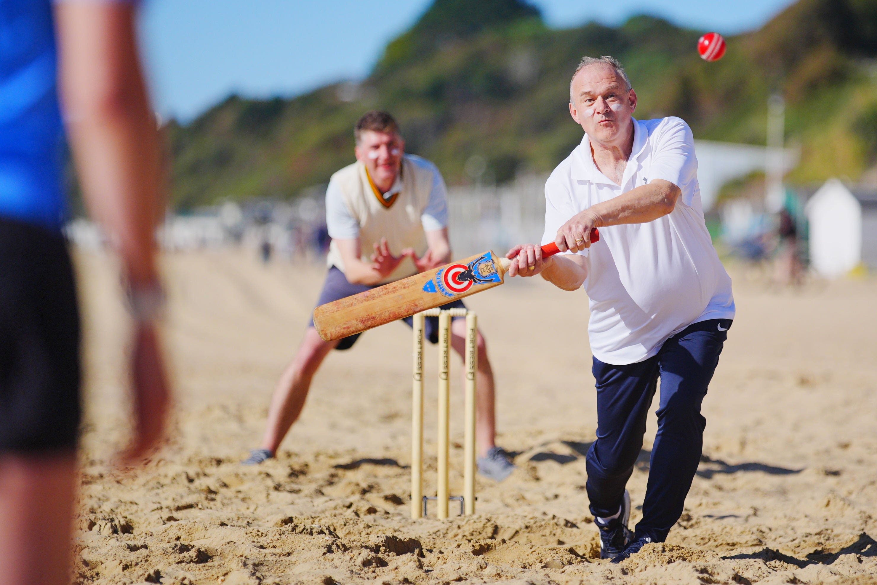 Sir Ed Davey batting during a game of beach cricket (Ben Birchall/PA)
