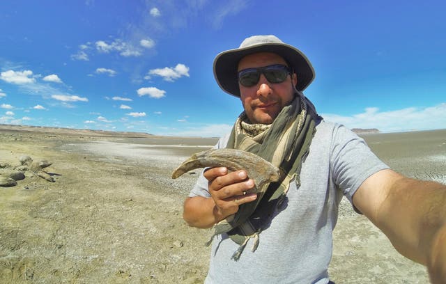 <p>This undated image provided shows researcher Marcelo Luna holding a claw belonging to a type of dinosaur called a megaraptoran in Chubut, Argentina</p>
