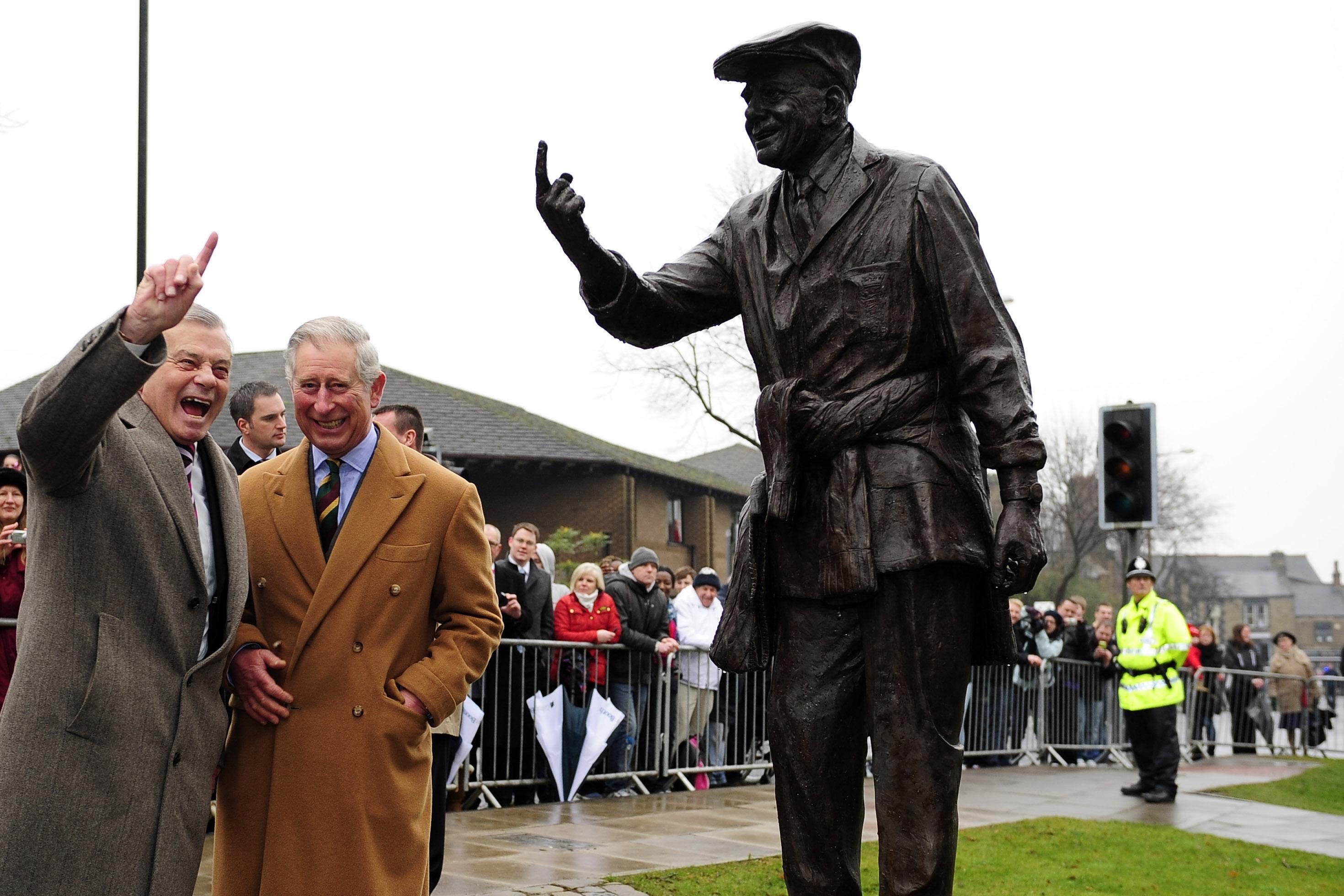 The then Prince of Wales and former cricket umpire Dickie Bird look at his statue in Barnsley during a visit to the town in 2012 (John Giles/PA)