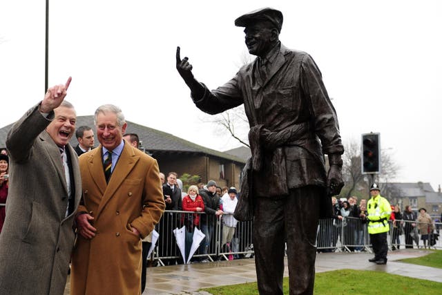 The then Prince of Wales and former cricket umpire Dickie Bird look at his statue in Barnsley during a visit to the town in 2012 (John Giles/PA)