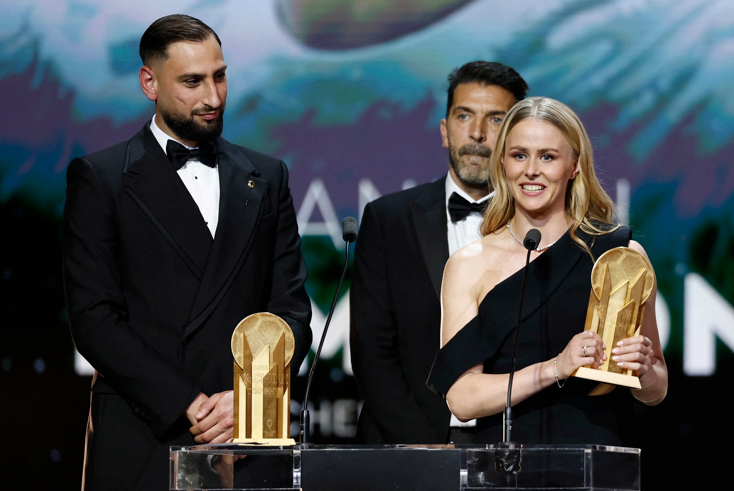 <p>England's goalkeeper Hannah Hampton and Italy's goalkeeper Gianluigi Donnarumma react after they both received the Yashin Trophy for the best goalkeepers during the 2025 Ballon d'Or France Football award ceremony </p>