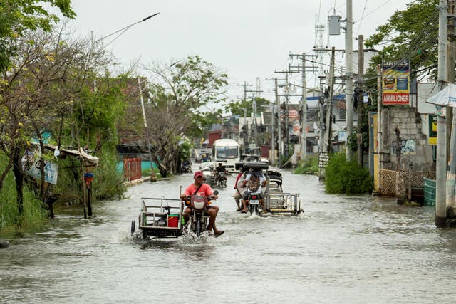 <p>Motorists drive along a flooded road following Typhoon Ragasa, in Pampanga province, Philippines</p>