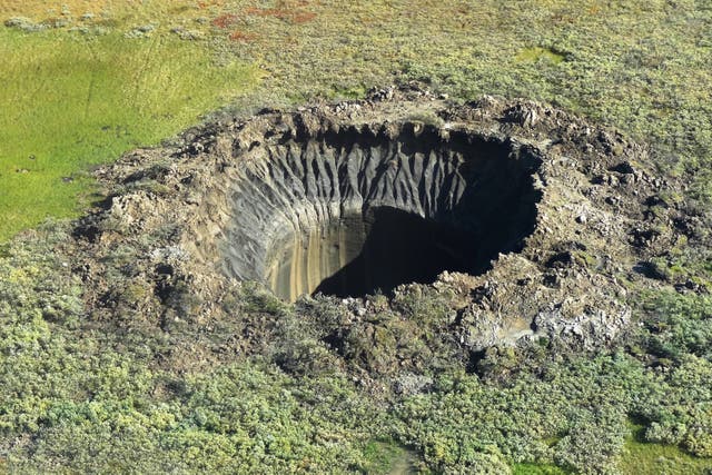 <p>An aerial view from onboard a helicopter taken on August 25, 2014 shows a crater on the Yamal Peninsula, northern Siberia</p>
