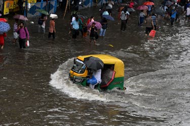 <p>People cross a waterlogged street after heavy rain in Kolkata, India, on 23 September 2025</p>