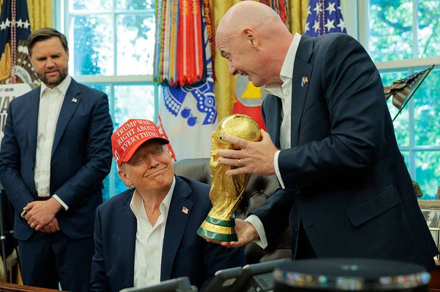<p>FIFA President Gianni Infantino shows U.S. President Donald Trump the World Cup Trophy in the Oval Office as Vice President JD Vance looks on August 22 in Washington, DC</p>